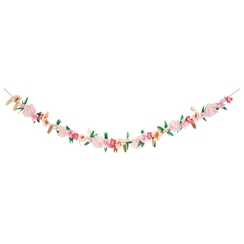 rose paper flower garland hanging on a rope. There are green paper leaves and gold leaves between the tissue papaer flowers.