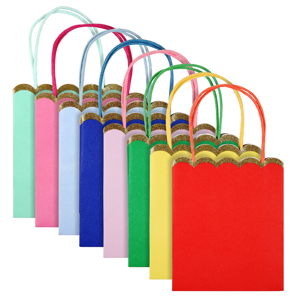 mulit colour party loot bags are lined up from red to yellow to green to lavender to dark blue to light blue to pink to mint with gold glitter detail on the scalloped edge